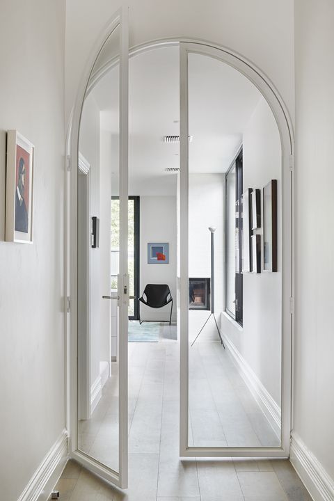 a minimalist home in white, with black touches for some drama and very delicate arched glass doors in white frames is amazing