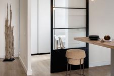 a minimalist home with a matching minimalist black frame metal sliding door that separates the spaces well enough and still rpovides both of them with light