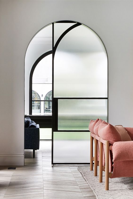 a modern and refined space made catchier with an arched doorway and styled with a sliding pocket door for a more modern feel
