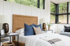 a modern farmhouse bedroom with a blue bench with pillows, a large window and an additional clerestory one