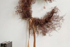 a moody dried flower and herb crescent moon Halloween wreath with tan silk ribbon is a stylish idea for the fall, too
