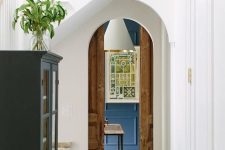 a narrow arched doorway styled with stained wood pocket doors is a pretty solution to preserve some original details of the house