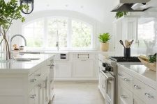 a neutral kitchen with a large arched window that floods the space with light and makes it more chic