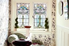 a refined vintage space done with floral wallpaper and a stained glass window plus a chic couch is a fantastic idea