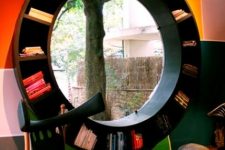 a round window styled as a bookcase, with the view of the garden and lots of books is a unique and bold idea for a reading nook
