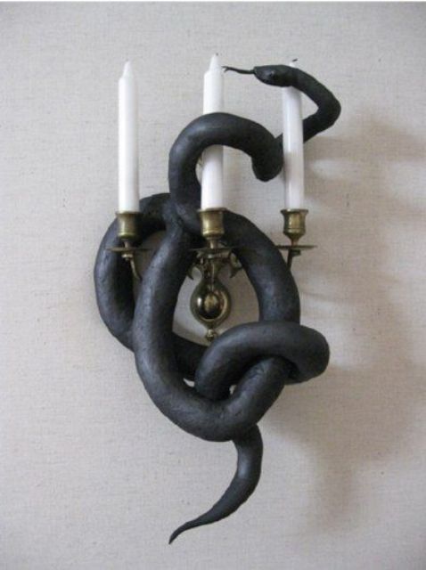 a wall candelabra covered with a faux black snake is a cool solution for Halloween and is very easy to DIY