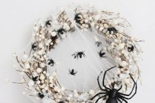 a white halloween wreath with spiders