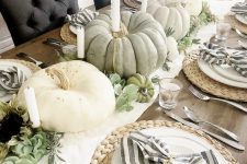 a white runner, heirloom pumpkins and candles, greenery, succulents, woven placemats, striped napkins
