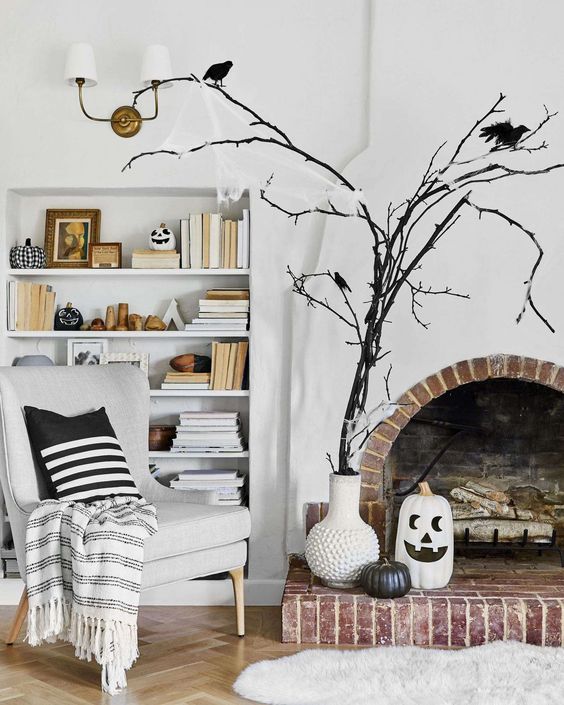a white vase with black branches and blackbirds, a black and a white pumpkin, black and white pumpkins on the shelves