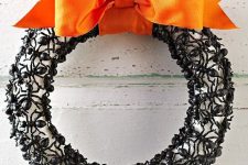 an elegant Halloween wreath covered with plastic ants, with a black orange ribbon bow is a scary and bold idea