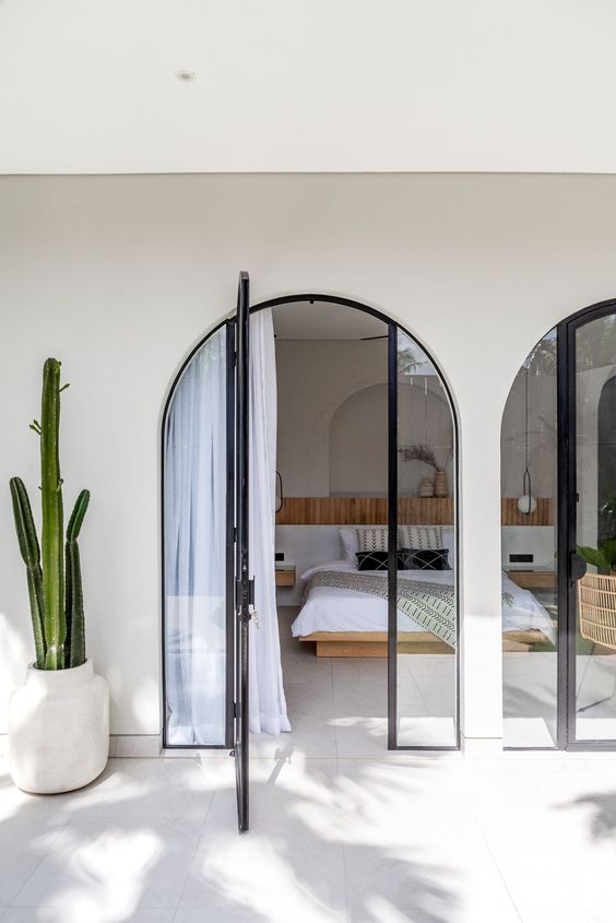 arched glass doors leading to the bedroom with no windows provide enough light for the space keeping it private at the same time