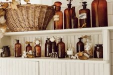 bathroom shelves with amber bottles, fall leaves, cotton and dried herbs will bring a fall spirit to the space