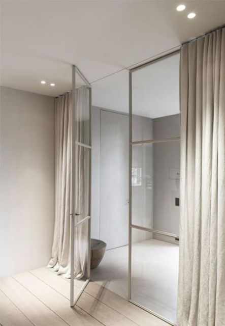 beige metal framing doors look ethereal and are covered with curtains for more privacy that glass doors usually don't give