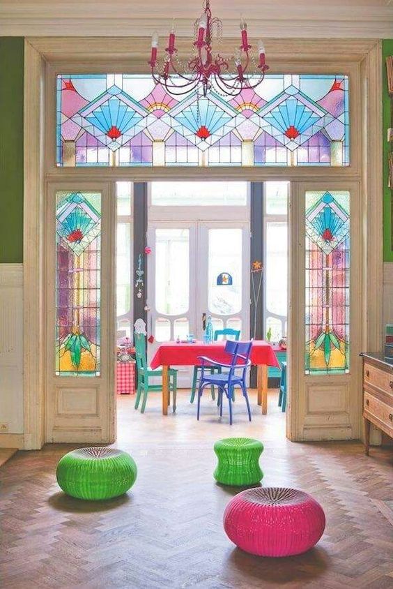 bold stained glass sidelights and doors plus colorful furniture and decor that echo with them for a bright and cool look