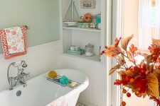 fall coastal bathroom decor with bright textiles, pumpkins and aqua-colored bottles plus a bold arrangement of leaves and berries