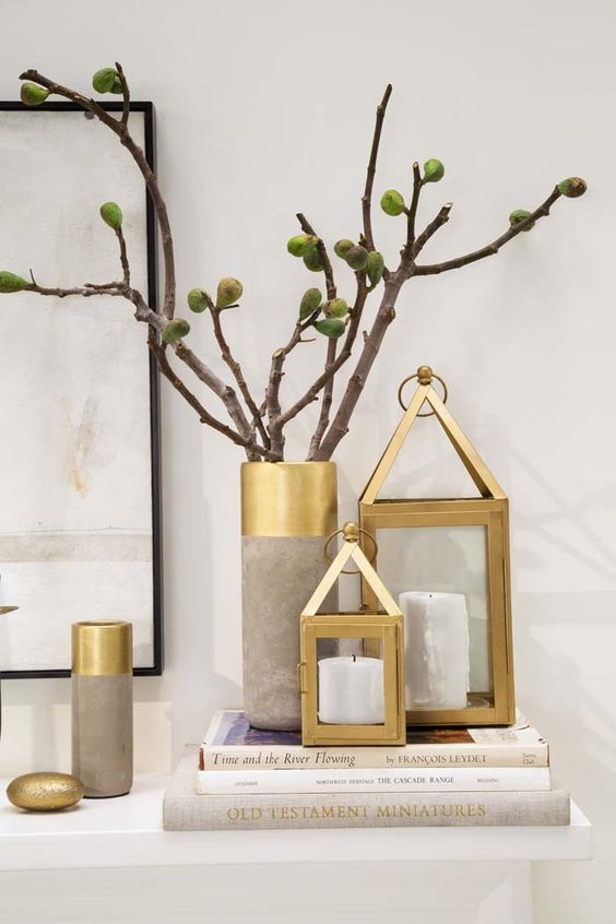 home decor done wiht brass candle lanterns, concrete and brass vases is amazing for decorating a contemporary or Scandinavian space