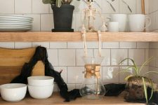 modern Halloween shelf styling with a skeleton and a black garland is very easy to realize and looks non-cheesy