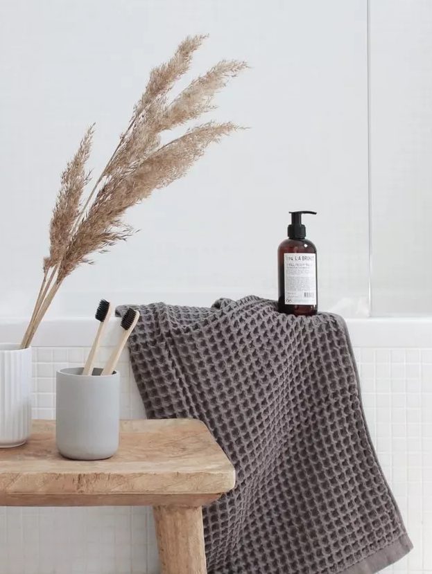 pampas grass in a neutral vase and some fluffy and cozy towels will make your bathroom feel more autumnal and cozy