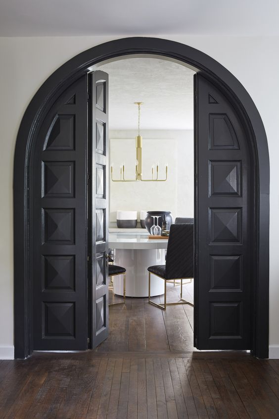 textural and carved black arched folding doors are a fantastic combo of modern and vintage - the design is vintage but the folding detail is pretty modern