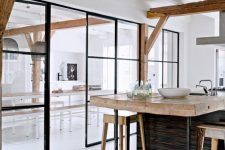 the kitchen and dining room divided with a framed glass wall with a door is a great idea to separate the space but do it gently