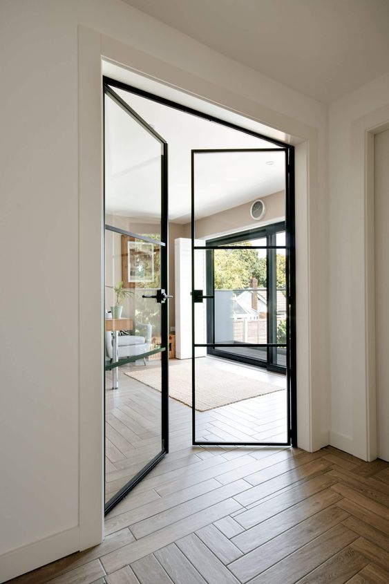 very delicate black metal frame glass doors with black handles are amazing to separate the living room from the rest of the house and let light in and out