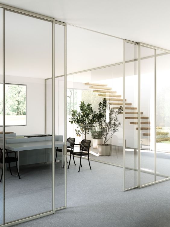 zoning the open layout with glass walls and white frame glass sliding doors in them is a cool way to separate the spaces