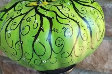 03 a catchy and refined neon green painted pumpkin on a black stand as a Halloween decoration for a vintage party