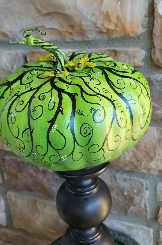 a catchy and refined neon green painted pumpkin on a black stand as a Halloween decoration for a vintage party