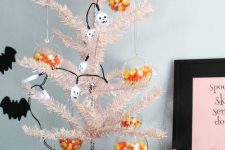 04 a blush Halloween tree decorated with skulls and with clear Halloween ornaments filled with corn candies