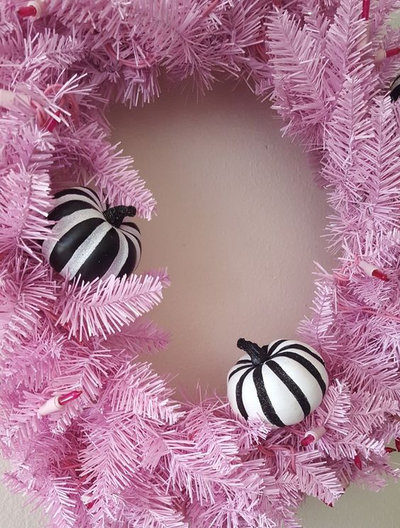 a gorgeous faux evergreen Halloween wreath with black and white stipred pumpkins is a perfect idea for your front door