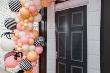 11 a pink, orange, yellow and striped balloon garland with giant spiders and bats is a gorgeous solution for Halloween
