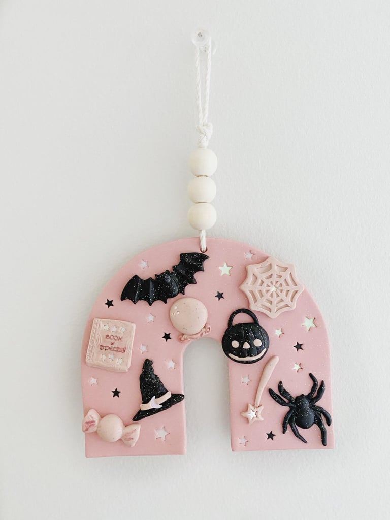 a cool polymer clay Halloween ornament decorated with spiders, bats, spiderwebs, wooden beads and other stuff