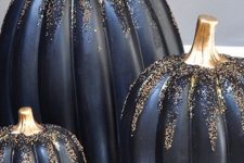 14 a trio of refined and glam black pumpkins covered with gold and black glitter are amazing for Halloween decor