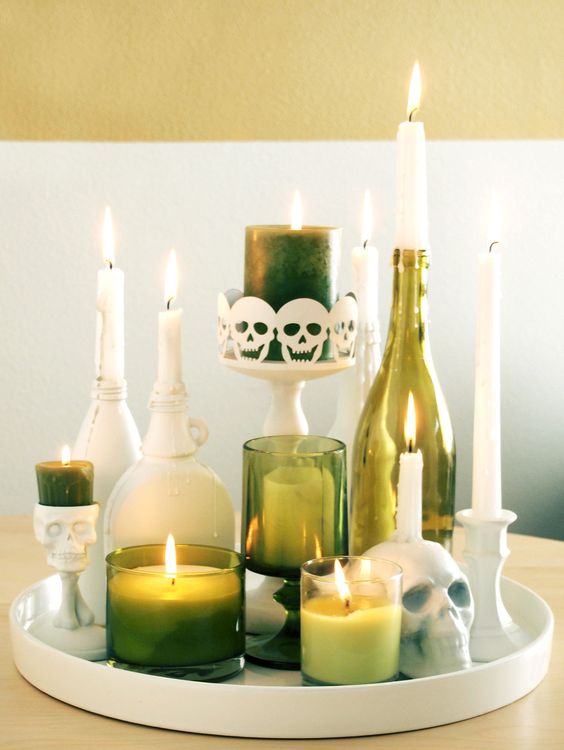 an extremely elegant Halloween centerpiece or decoration of green candleholders, bottles and candles paired up with white ones