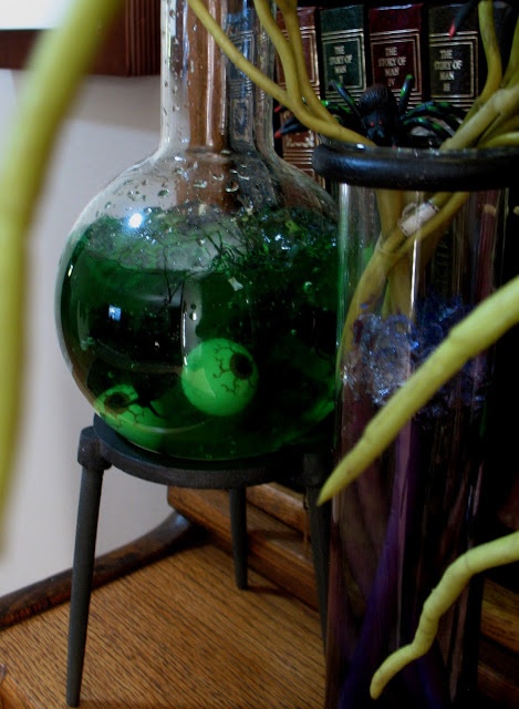 an oversized test tube with green solution and some eyeballs is an easy Halloween decoration you can make yourself