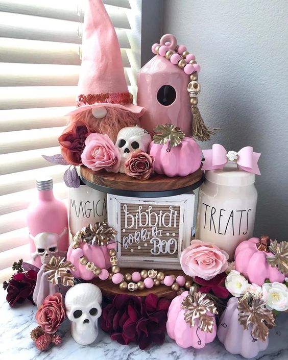 amazing pink Halloween decor with pink pumpkins, bottles, a gnome, some bows, beads and skulls is gorgeous