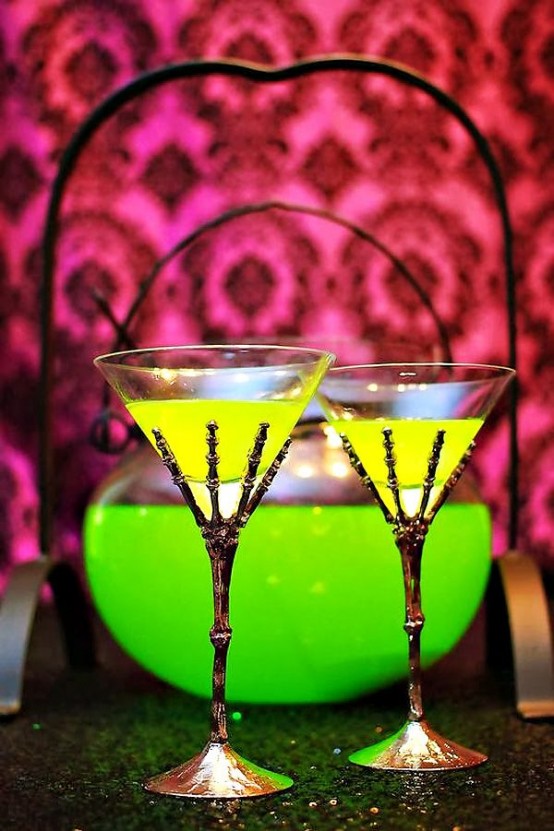 neon green Halloween drinks in glasses holded by skeleton hands - yes, please