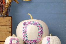 23 white pumpkins with pink floral monograms painted are a non-typical and very cute Halloween decor idea