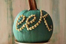 24 a chic matte green pumpkin decorated with gold beads is a chic and stylish decoration for Halloween