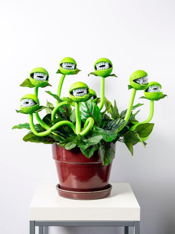 a man-eating plant in neon greens put in a usual planter is a creative and fun decoration for Halloween