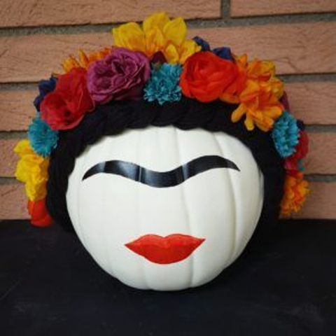 a painted pumpkin showing off Frida Kahlo with her bold makeup and a colorful floral crown