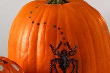 26 a natural orange pumpkin decorated with black sequins showing a spider is a beautiful and very cool idea that you can realize last minute
