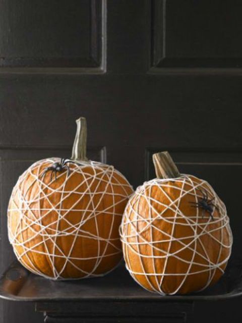 pumpkins wrapped with yarn and black spiders are simple and great decoration for Halloween