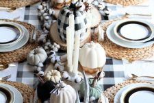 a beautiful and cozy thanksgiving tablescape with a buffalo check table runner and a matching pumpkin, cotton, antlers and woven chargers