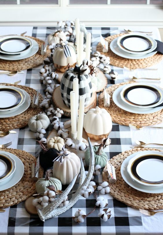 a beautiful and cozy thanksgiving tablescape with a buffalo check table runner and a matching pumpkin, cotton, antlers and woven chargers