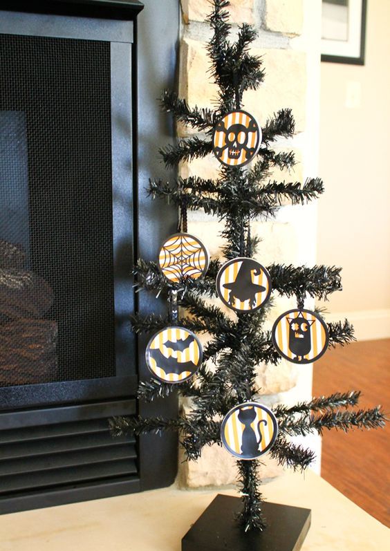 a black Halloween tree with round ornaments that show off bats, cats, skulls, spiderwebs is a very fun and creative idea