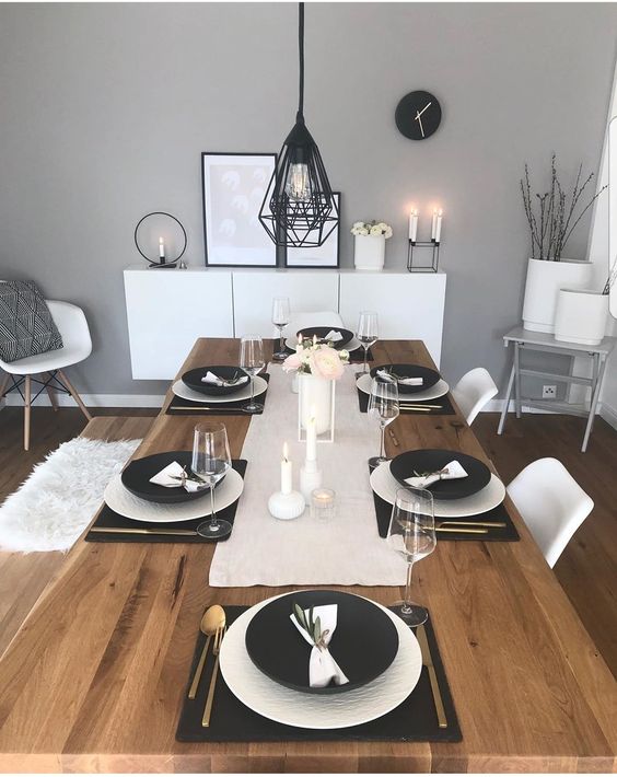 a chic Scandinavian tablescape with black and white porcelain, white linens, black placemats, white candles