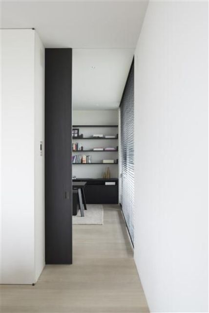 a contemporary space with black accents and a black double height pocket door that is another color accent in the space
