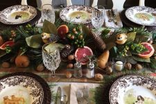 a fab woodland Thanksgiving tablescape with neutral linens, patterned plates and woven chargers, a lush centerpiece of pinecones, pears, berries and citrus