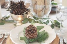 a gorgeous woodland table setting like this one will do for both Thanksgiving and Christmas, with its pinecones, evergreens and plaid napkins